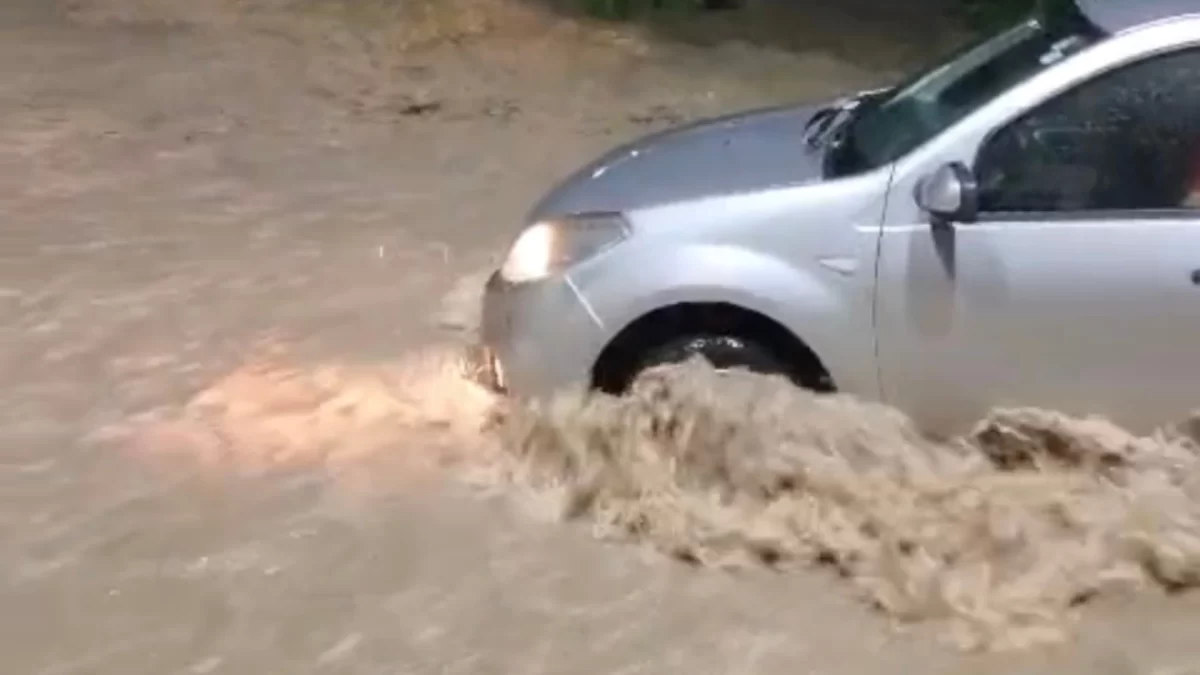 Carro atravessa rua alagada em Divinópolis